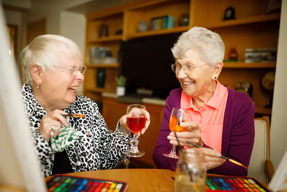 Two friends enjoying wine and painting